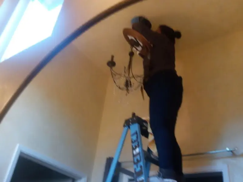 Electrician installing a chandelier in a Orangeburg residence